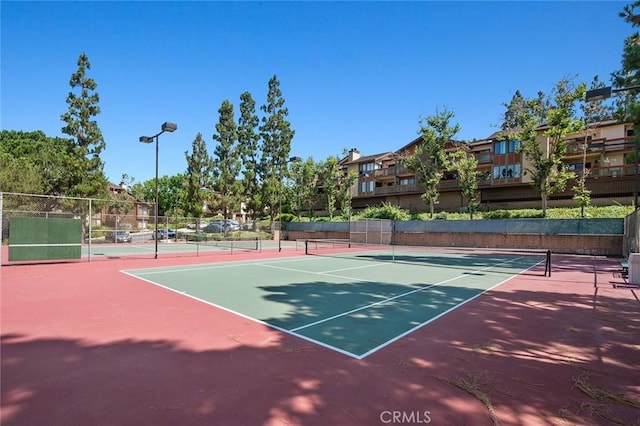 view of tennis court with fence and community basketball court