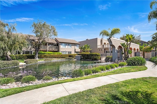 view of front of house featuring stucco siding and a garden pond