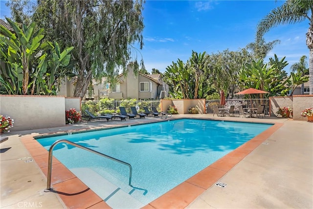 pool with fence and a patio area