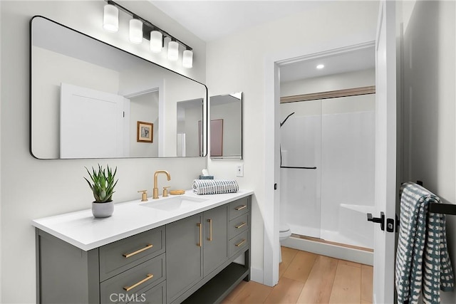 full bathroom with toilet, wood finished floors, vanity, recessed lighting, and a stall shower