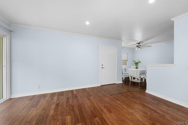 spare room with ornamental molding, wood finished floors, baseboards, and ceiling fan