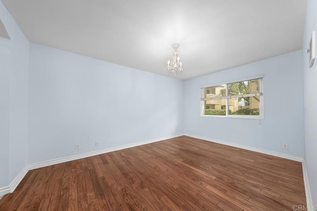 9939 Erma Rd Unit 101, San Diego, CA 92131 - empty room featuring a chandelier, baseboards, and wood finished floors