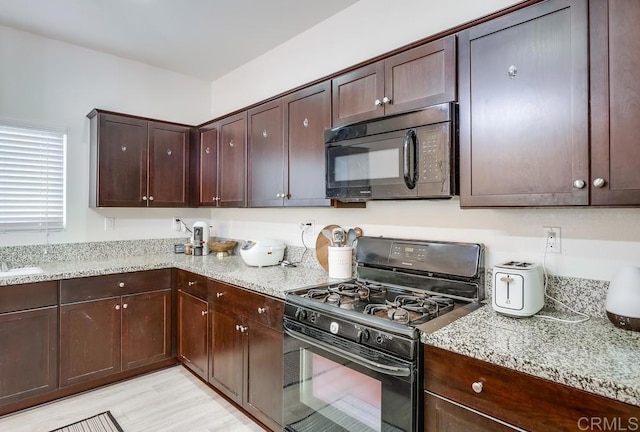 26841 Franklin Ave, Winchester, CA 92596 - kitchen with dark brown cabinets, black appliances, light stone countertops, and light wood-type flooring