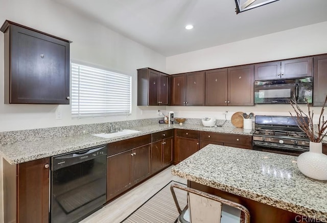 26841 Franklin Ave, Winchester, CA 92596 - kitchen featuring light stone countertops, light wood-style flooring, dark brown cabinets, a sink, and black appliances