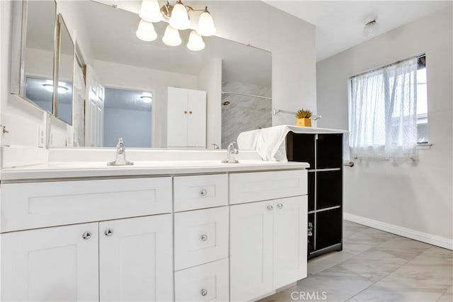bathroom featuring walk in shower, marble finish floor, a chandelier, double vanity, and baseboards