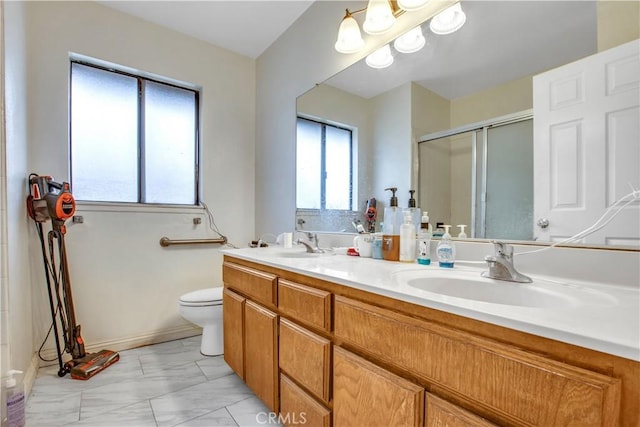 full bathroom featuring double vanity, toilet, a sink, a shower stall, and marble finish floor