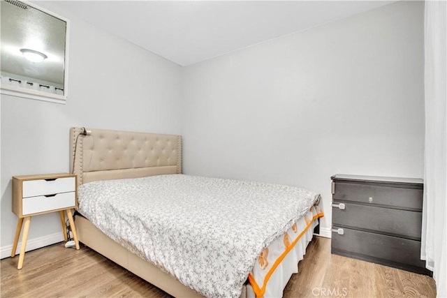 bedroom with baseboards and wood finished floors