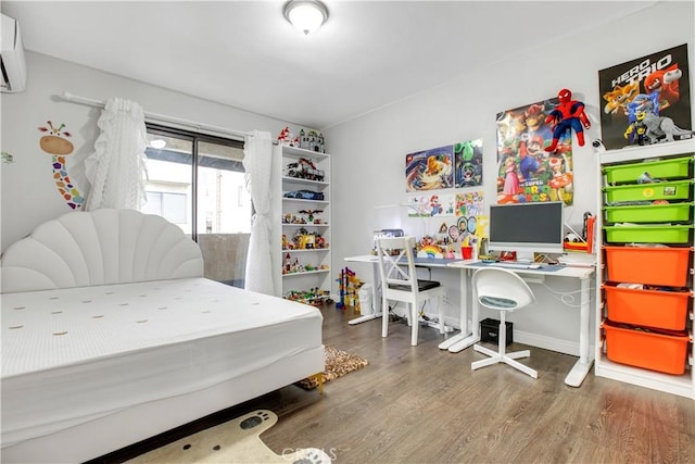 bedroom with a wall unit AC and wood finished floors