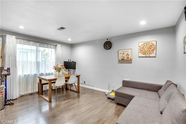 living area featuring visible vents, light wood-style flooring, and recessed lighting