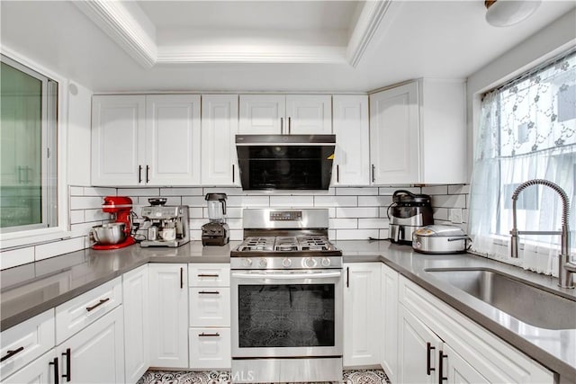 kitchen featuring a sink, white cabinetry, gas range, backsplash, and a raised ceiling