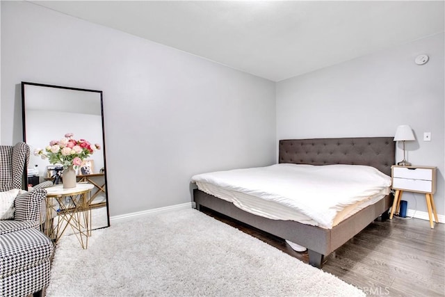 bedroom with baseboards and wood finished floors