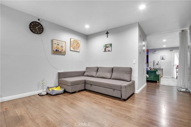 living room featuring baseboards, hardwood / wood-style floors, and recessed lighting