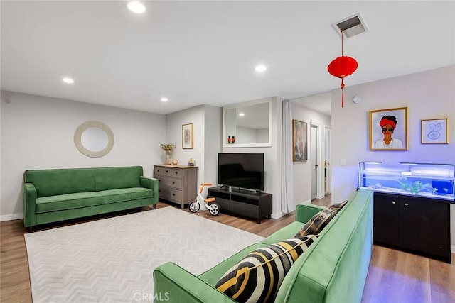 living area featuring visible vents, wood finished floors, baseboards, and recessed lighting