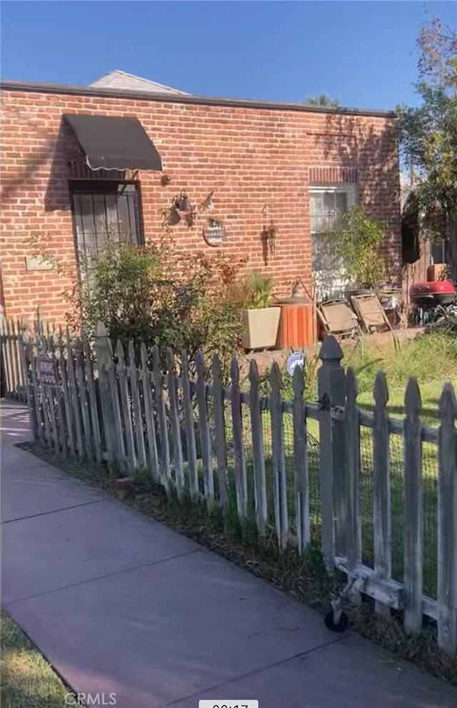 1525 N Arrowhead Ave, San Bernardino, CA 92405 - view of side of home with brick siding and fence private yard