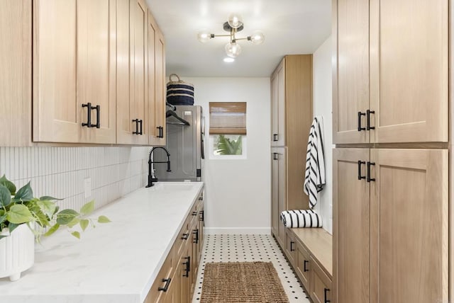 mudroom with a sink and baseboards