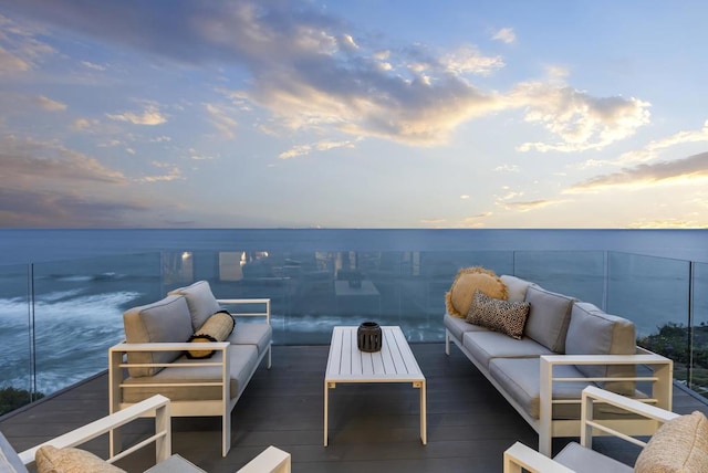 deck with an outdoor living space and a water view