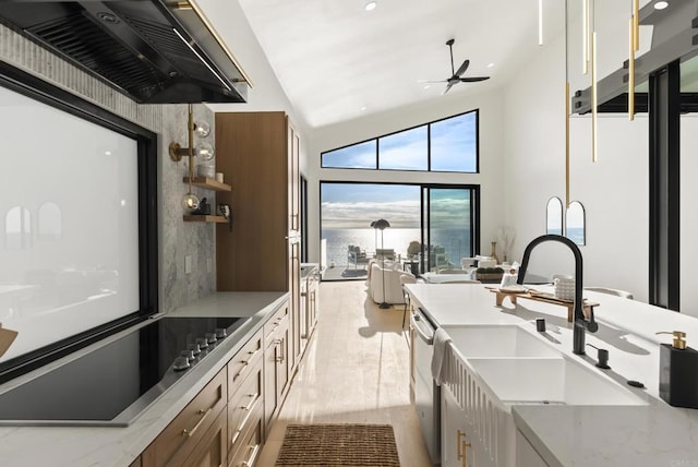 kitchen featuring a sink, wall chimney exhaust hood, vaulted ceiling, a ceiling fan, and black electric cooktop