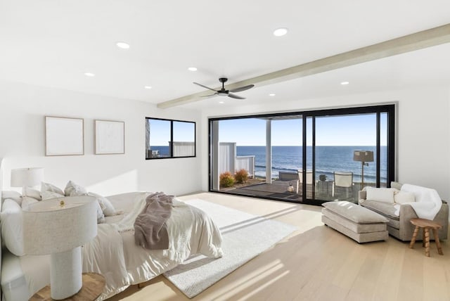 bedroom with recessed lighting, a water view, wood finished floors, beamed ceiling, and access to exterior