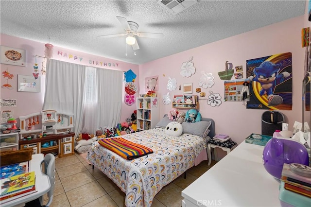 bedroom with tile patterned flooring, a textured ceiling, ceiling fan, and visible vents