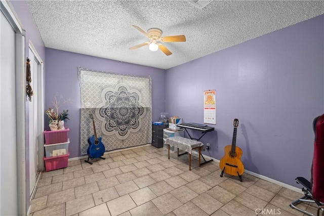 living area with ceiling fan, a textured ceiling, baseboards, and visible vents