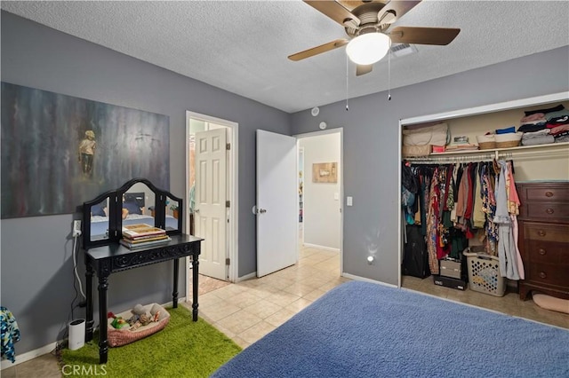tiled bedroom featuring a closet, a textured ceiling, baseboards, and a ceiling fan