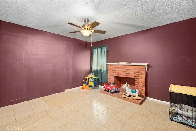 unfurnished living room with a fireplace, ceiling fan, a textured ceiling, and baseboards