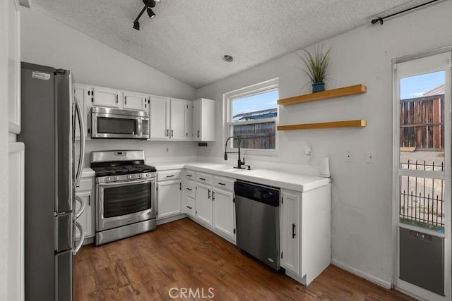 1009 Fairwind Ave, Rosamond, CA 93560 - kitchen with a sink, stainless steel appliances, white cabinets, a textured ceiling, and lofted ceiling
