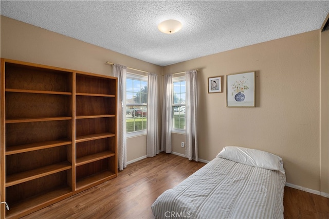 1009 Fairwind Ave, Rosamond, CA 93560 - bedroom featuring a textured ceiling, wood finished floors, and baseboards