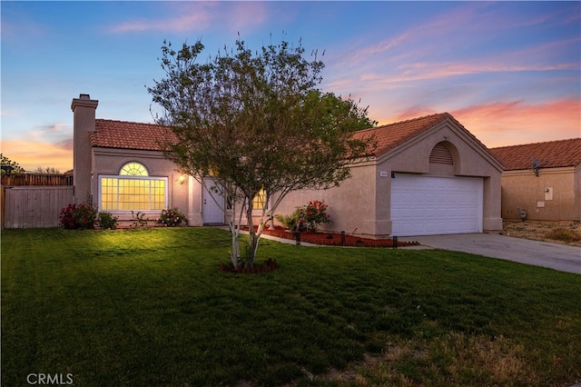 1009 Fairwind Ave, Rosamond, CA 93560 - view of front of home featuring a chimney, driveway, a yard, a garage, and stucco siding