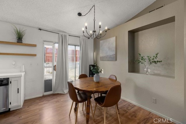 1009 Fairwind Ave, Rosamond, CA 93560 - dining room featuring a textured ceiling, a notable chandelier, baseboards, and wood finished floors