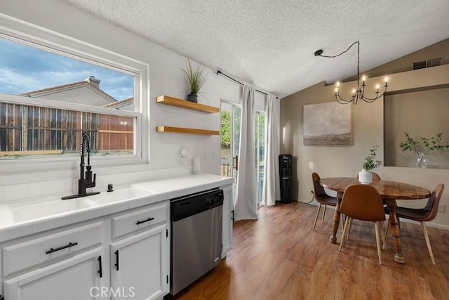 1009 Fairwind Ave, Rosamond, CA 93560 - kitchen featuring a sink, a textured ceiling, an inviting chandelier, plenty of natural light, and stainless steel dishwasher