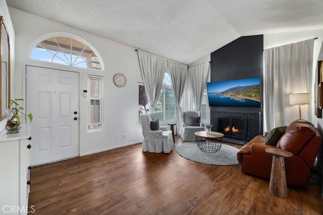 1009 Fairwind Ave, Rosamond, CA 93560 - entrance foyer with a textured ceiling, wood finished floors, lofted ceiling, and a brick fireplace