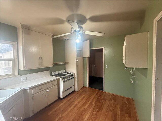 3754 Grace Ave, Baldwin Park, CA 91706 - kitchen featuring a ceiling fan, white gas range, light countertops, white cabinets, and light wood-type flooring
