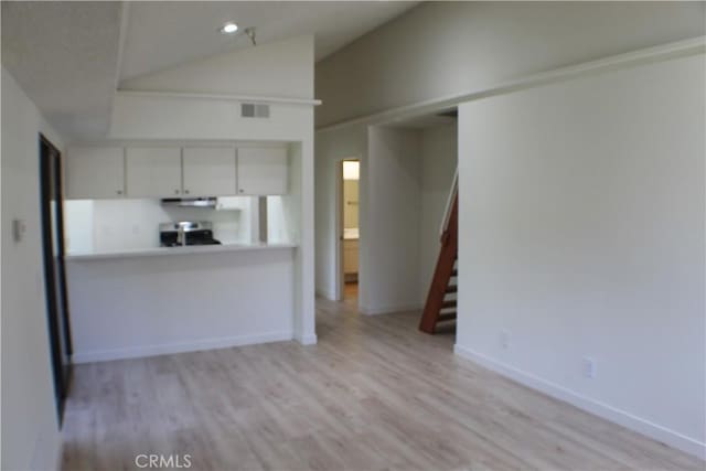 44406 15th St E Unit 13, Lancaster, CA 93535 - kitchen with range, lofted ceiling, light wood-style flooring, white cabinetry, and ventilation hood