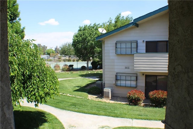 view of home's exterior featuring fence and a lawn