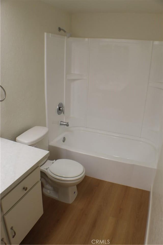 full bathroom featuring toilet, shower / bathing tub combination, wood finished floors, and vanity