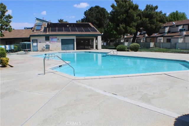 community pool with fence and a patio