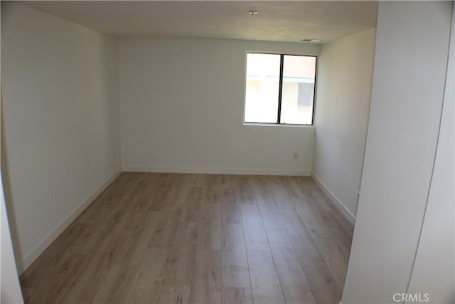 unfurnished room featuring light wood-type flooring and baseboards