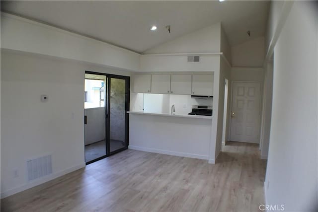 kitchen with stove, light wood-style flooring, and visible vents