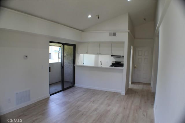 44406 15th St E Unit 13, Lancaster, CA 93535 - kitchen featuring range, light wood-type flooring, vaulted ceiling, recessed lighting, and white cabinets