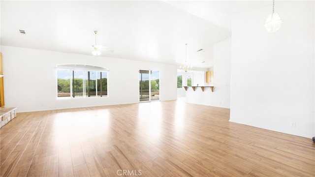 13912 Riverside Dr, Apple Valley, CA 92307 - unfurnished living room with an inviting chandelier, light wood-style flooring, lofted ceiling, and visible vents