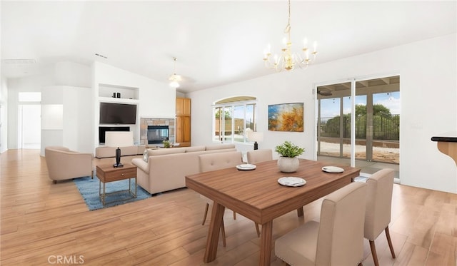 13912 Riverside Dr, Apple Valley, CA 92307 - dining room featuring an inviting chandelier, a fireplace, visible vents, light wood-style floors, and vaulted ceiling