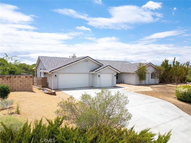 13912 Riverside Dr, Apple Valley, CA 92307 - view of front of property featuring fence, an attached garage, driveway, stucco siding, and a chimney