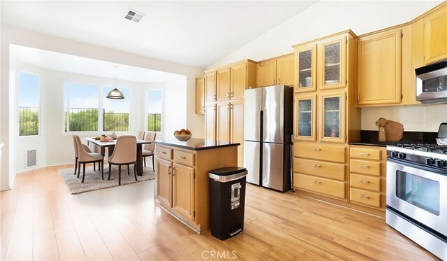 13912 Riverside Dr, Apple Valley, CA 92307 - kitchen featuring stainless steel appliances, light brown cabinetry, dark countertops, and visible vents