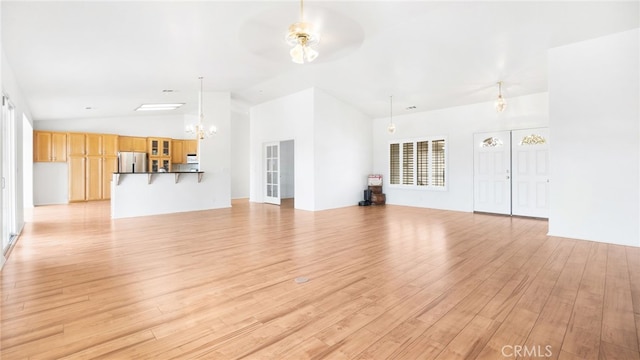 13912 Riverside Dr, Apple Valley, CA 92307 - unfurnished living room with light wood finished floors, lofted ceiling, and ceiling fan with notable chandelier