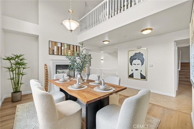 13031 Villosa Pl Unit 437, Playa Vista, CA 90094 - dining area featuring stairway, a high ceiling, baseboards, and a glass covered fireplace