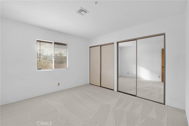 61652 Pueblo Trl, Joshua Tree, CA 92252 - unfurnished bedroom featuring two closets, carpet, and visible vents