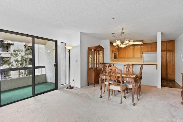 dining space featuring light carpet, a chandelier, and a textured ceiling