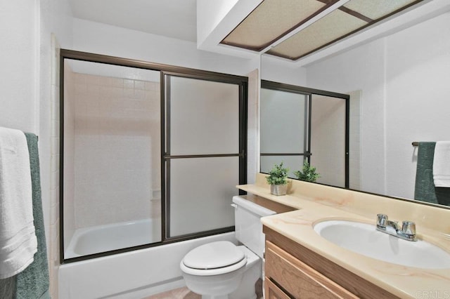 bathroom featuring toilet, vanity, and combined bath / shower with glass door