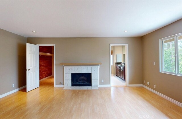 25211 Barents, Laguna Hills, CA 92653 - unfurnished living room featuring baseboards, a tiled fireplace, light wood-style flooring, and recessed lighting